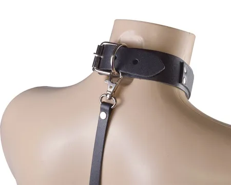 Crna ogrlica sa metalnim kopčama na bradavicama i povodcem